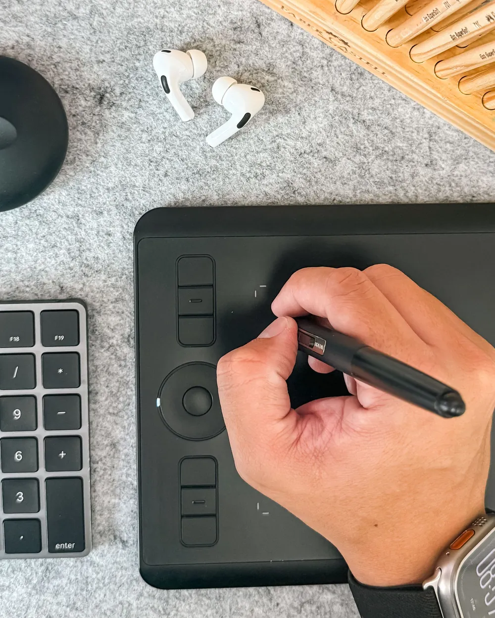 Hand zeichnet mit einem Stift auf einem Grafiktablett